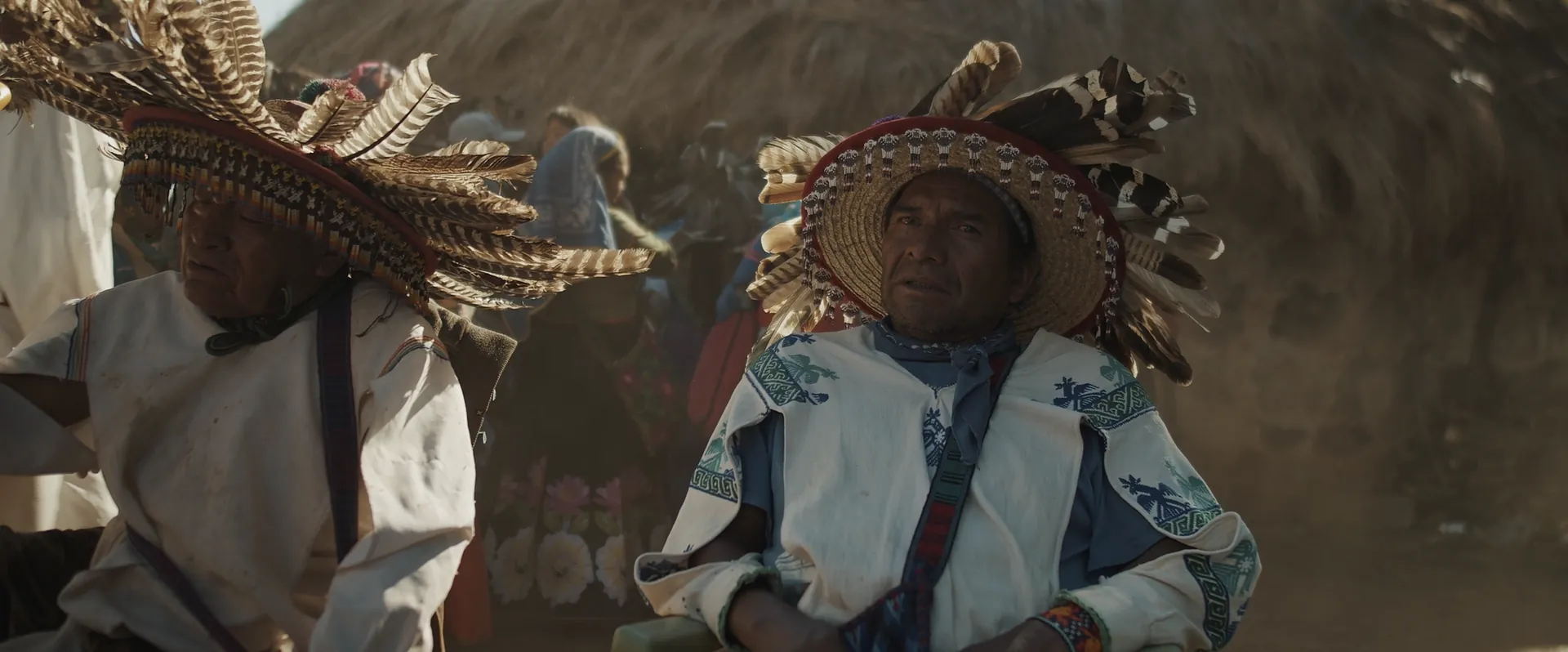 Two Wixárika men in feathered hats